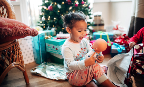 Young girl looking at doll