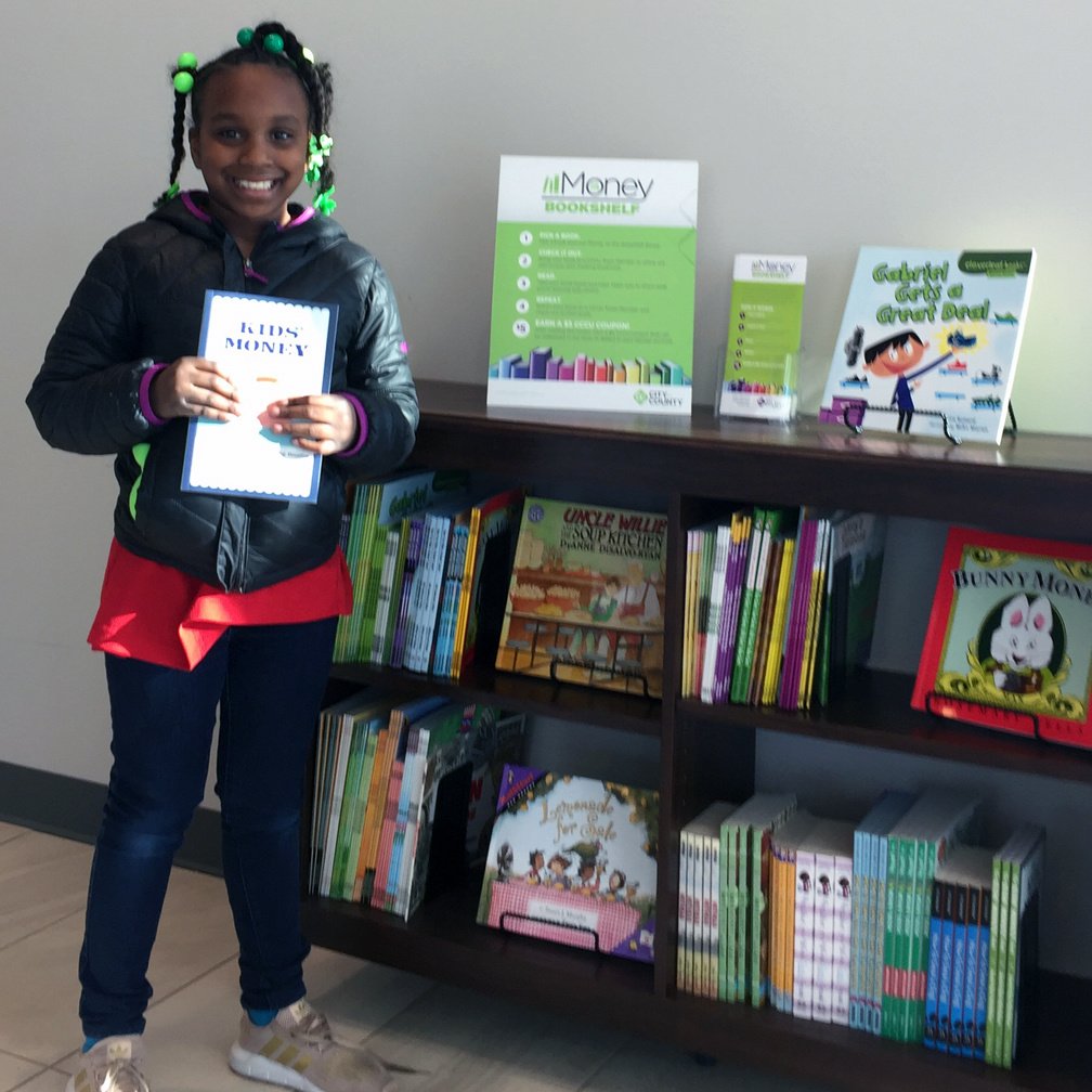 Little girl holding her favorite book from shelf