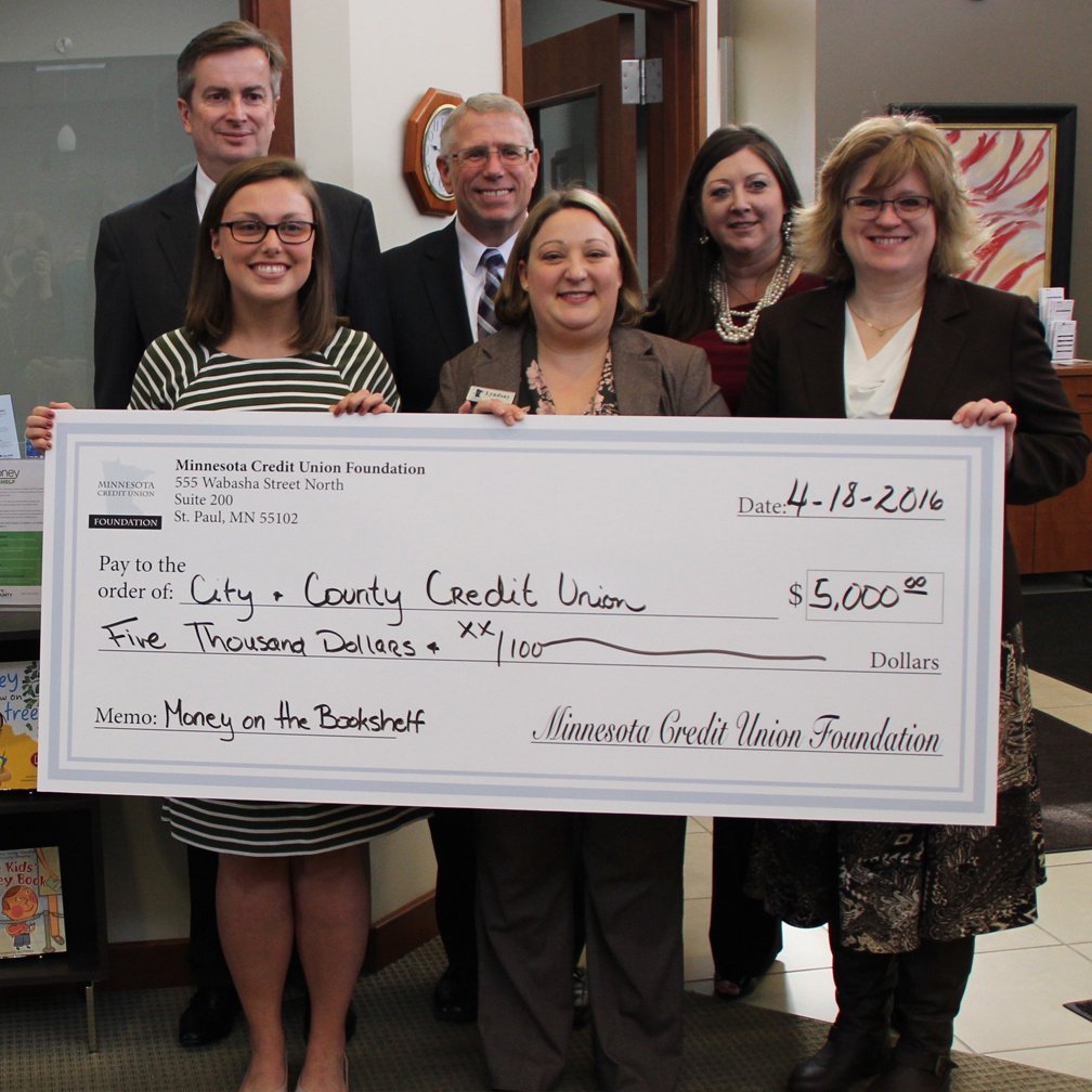 Team members standing with grant check