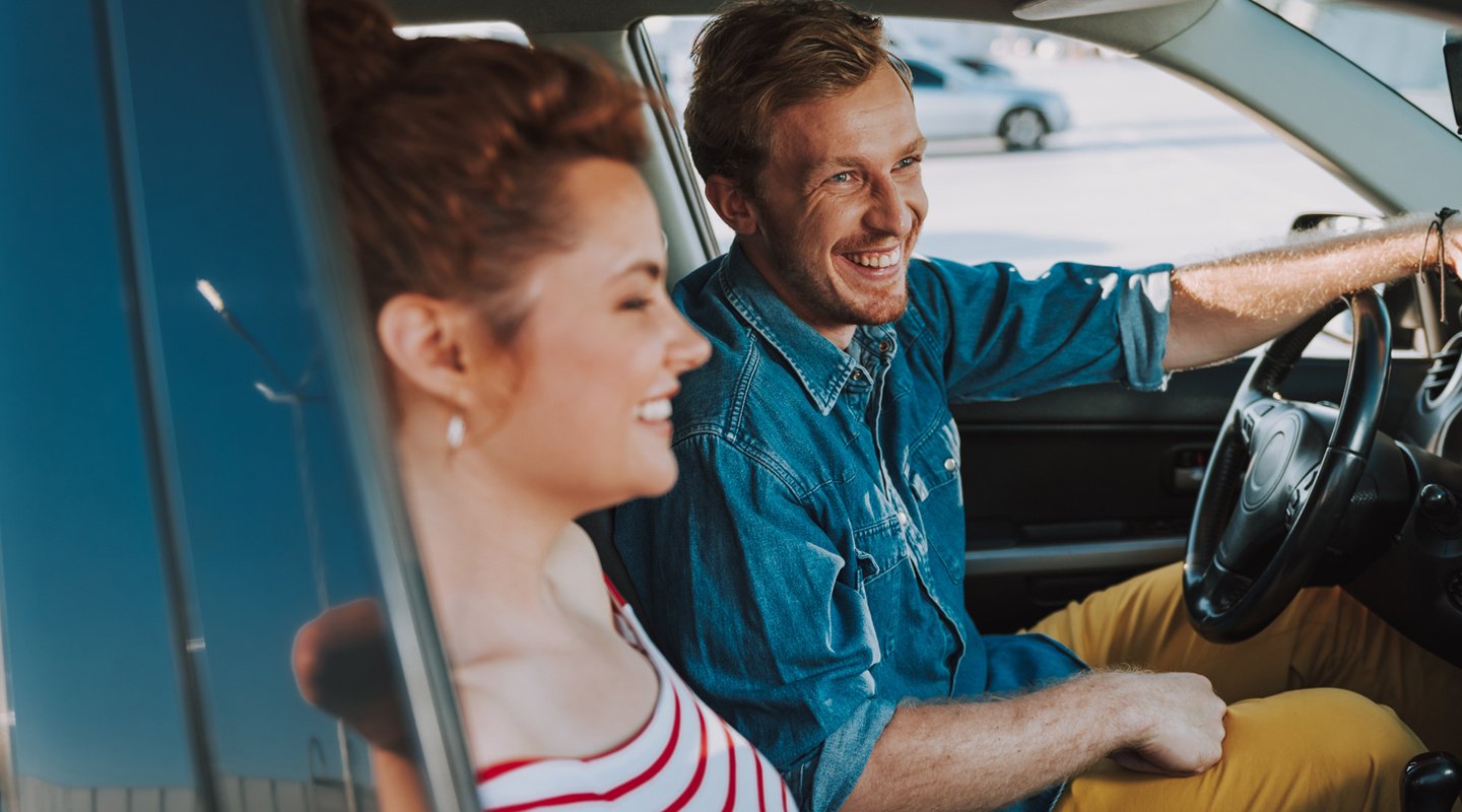 Couple driving in car together smiling